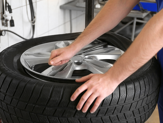 Telle Tire technician prying a tire off the wheel rim for a replacement.