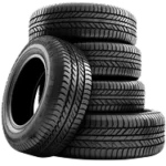 4 new tires stacked with another leaned on the side.